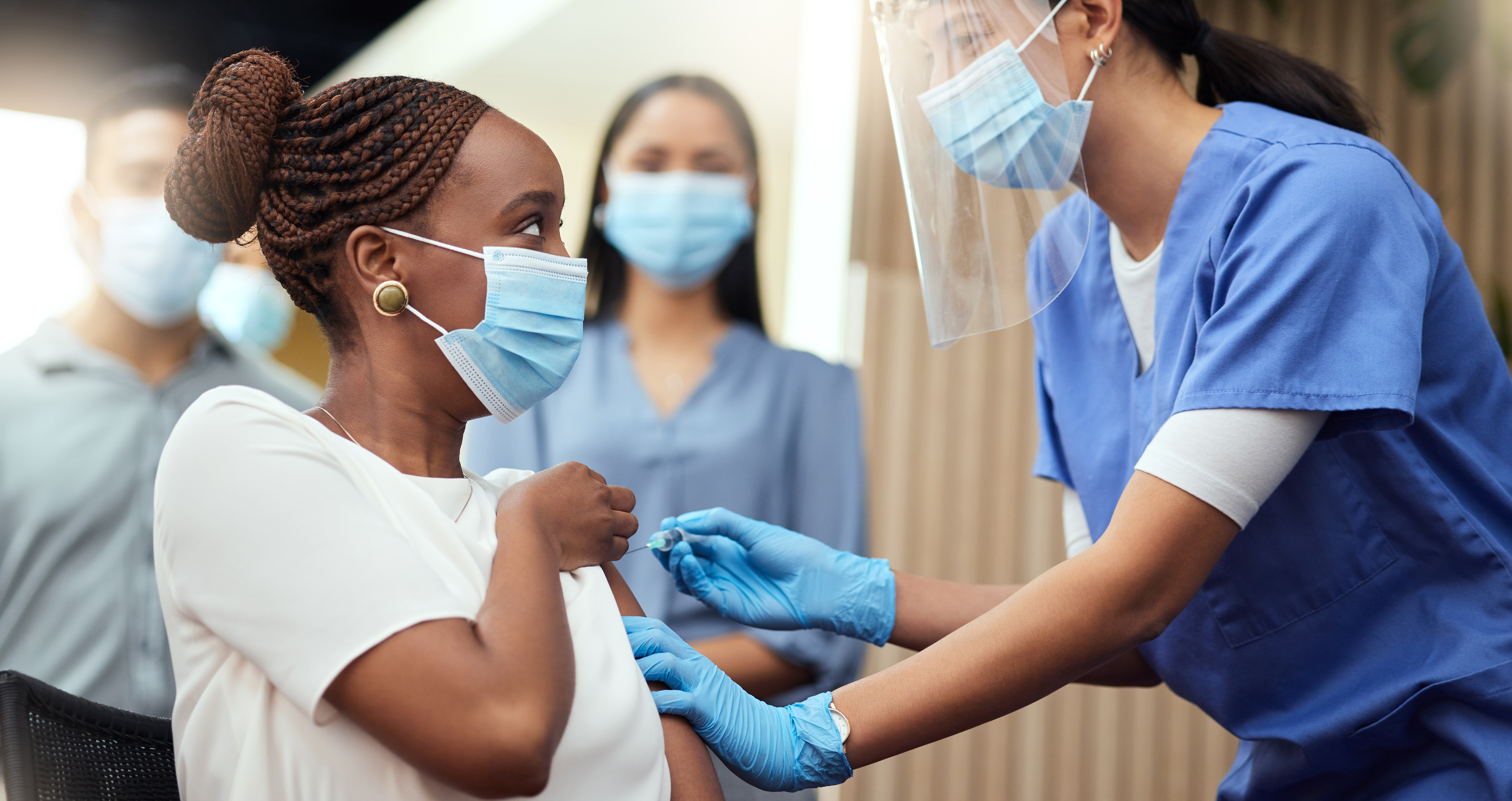 Woman receives a COVID-19 vaccine from a nurse.