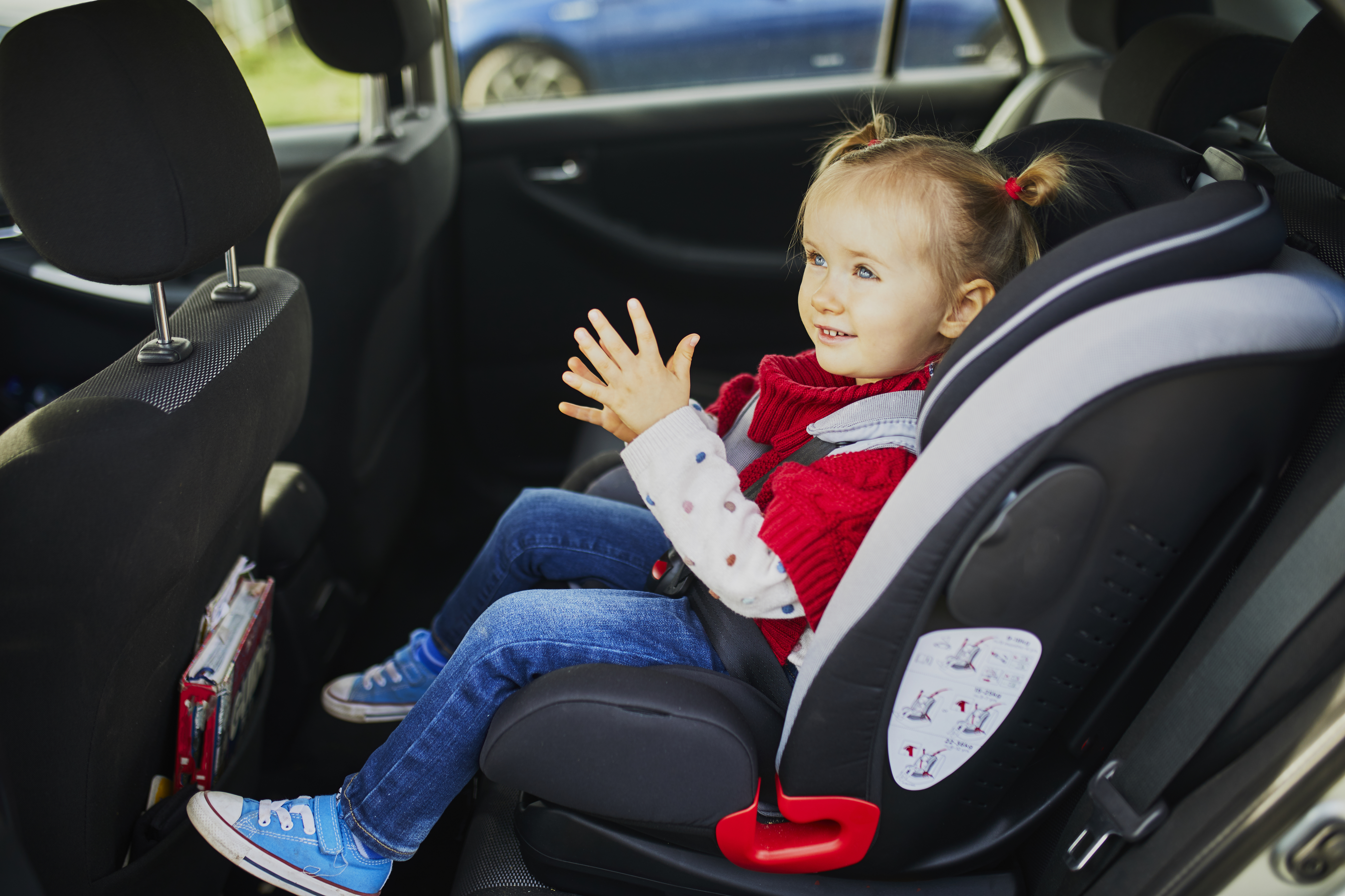 Young girl in a car seat.