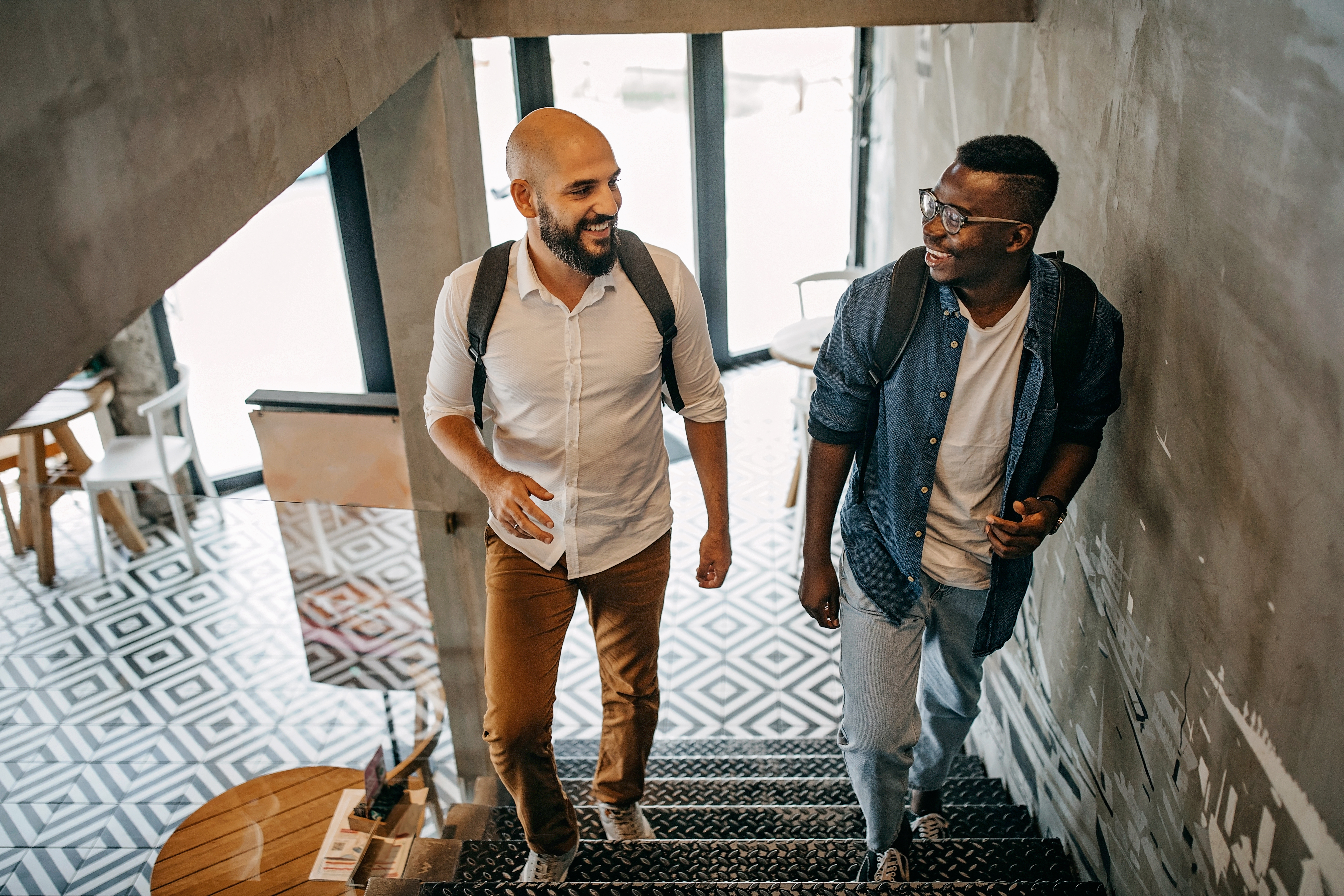 Two young men walk up stairs to attend a meeting.