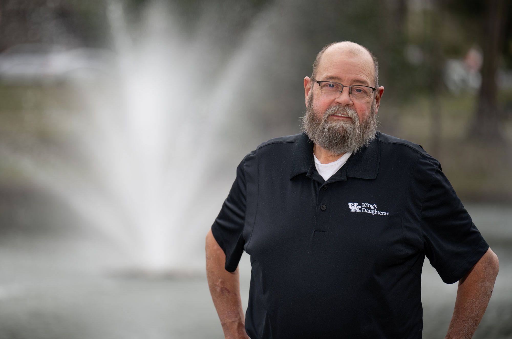 Tom Adams, a kidney transplant recipient, stands in front of a fountain at UK King's Daughters.