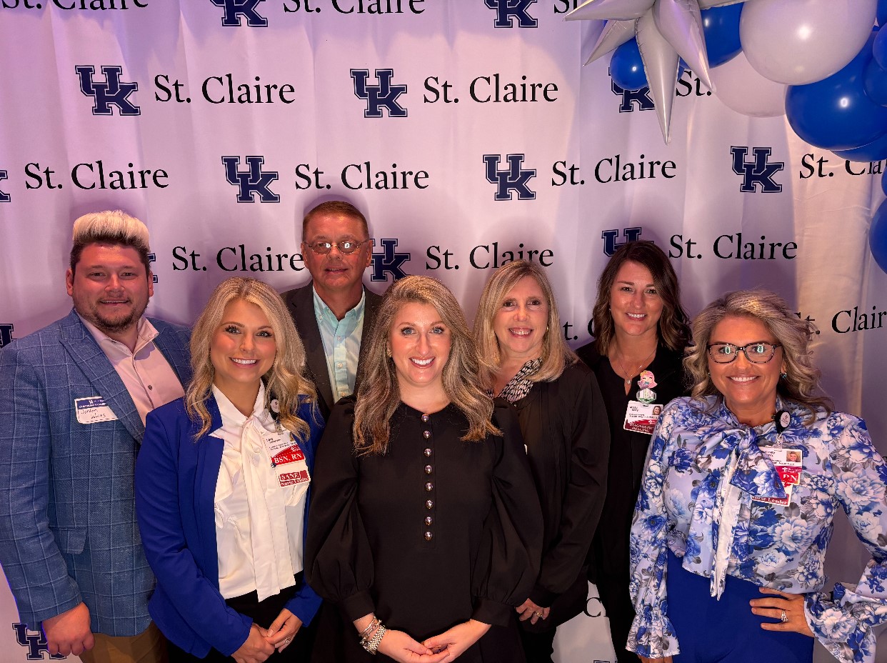 Members of the Gill Affiliate Network stand in front of a sign celebrating UK St. Claire.