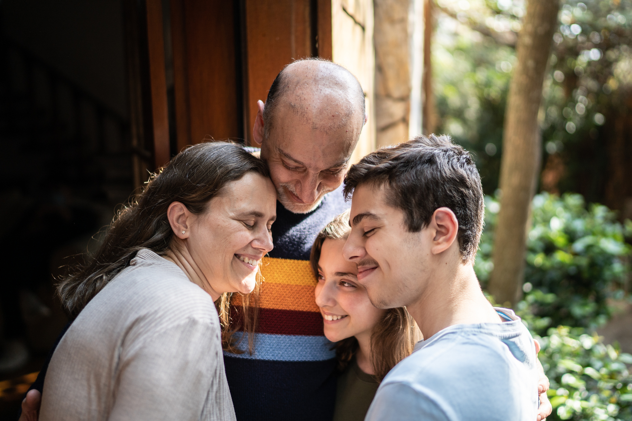 A supportive family of four embraces.