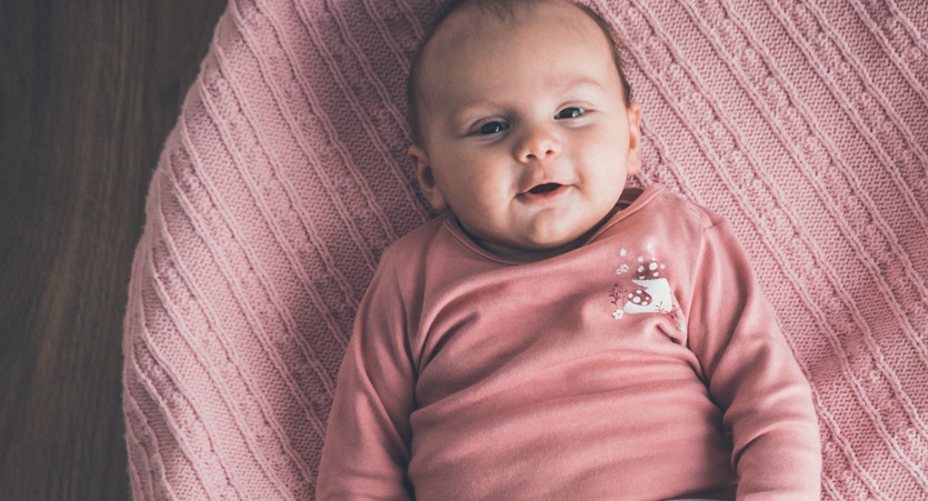 Baby lies in crib