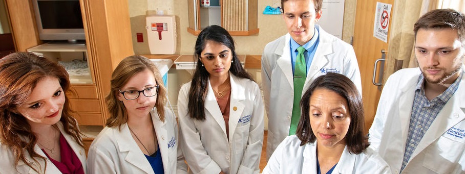 Group of medical students gather around a doctor.