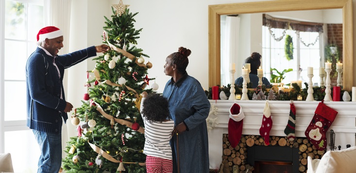 Family decorates a Christmas tree together.