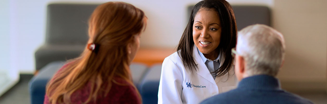 A doctor talks with a patient and family member.