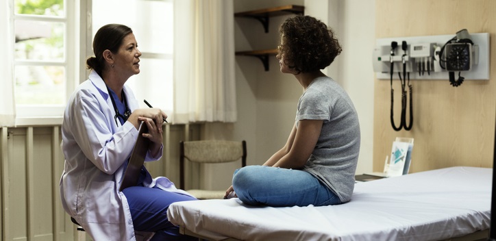 Doctor talks to teen patient.