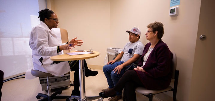 Dr. Ima Ebong speaks to her patient Zack and his mom, Nina