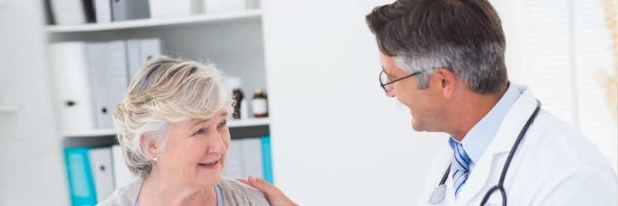 An elderly woman talks with her doctor.