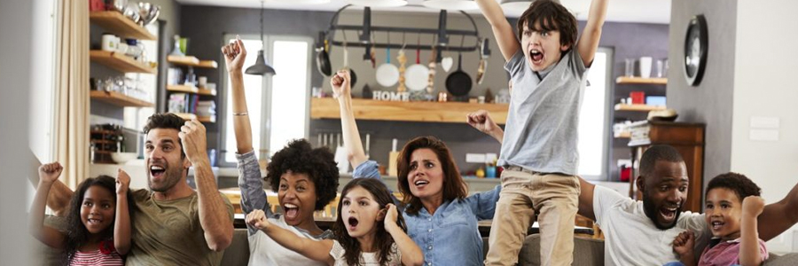 Families watch a sporting event together at home.