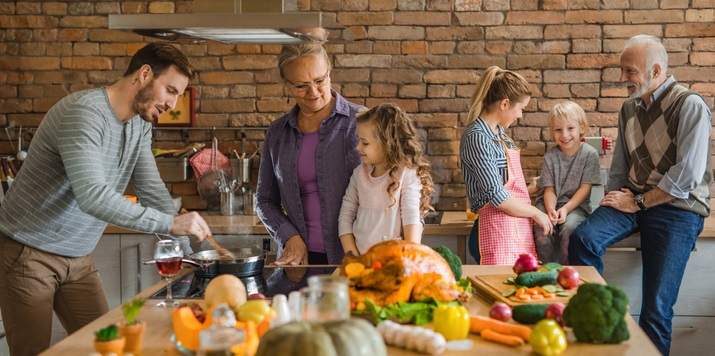 Family cooks together in kitchen.