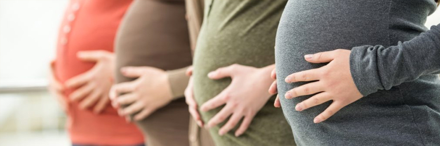 Four pregnant women stand in a row.