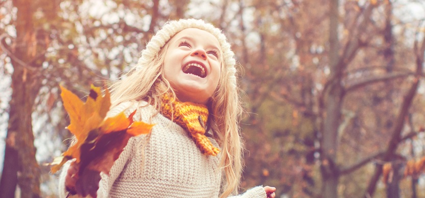 Young girl plays outside during fall