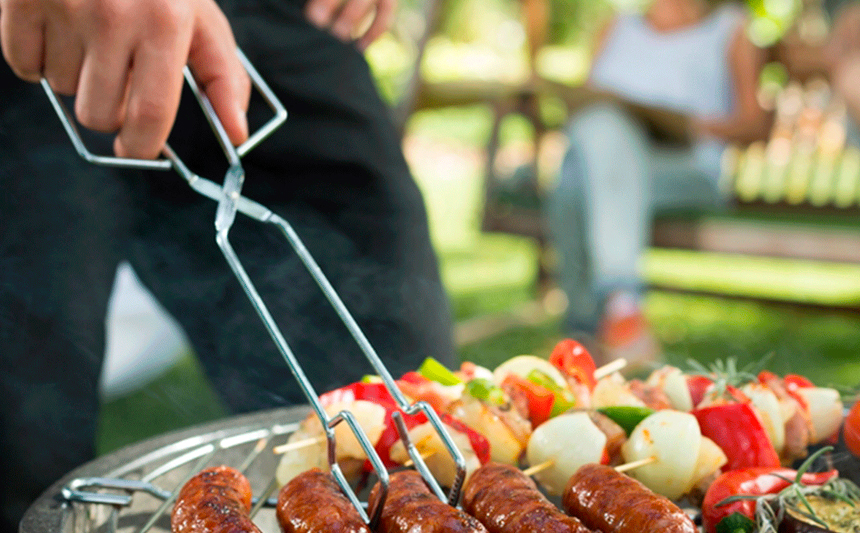 A man cooks on a backyard grill.