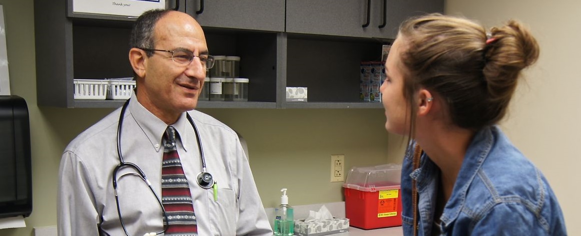 Dr. Hatim Omar speaks with a female patient.