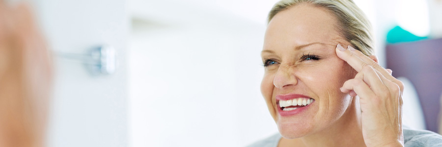 Woman lifting her eyelid in the mirror