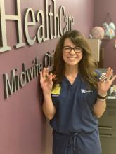 Dee Polito stands in the UK Midwife Clinic and holds pieces of mini candy.