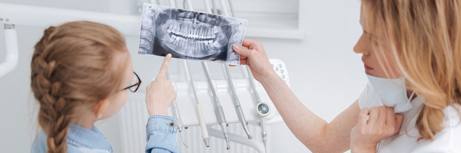 Young girl doctor looking at the scan of a jaw