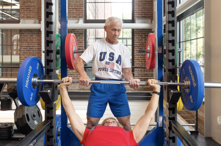 Joe Marsteiner spots his wife Cathy as she lifts weights.