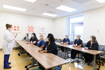 A group of Kentucky Neuroscience Institute providers gather in a classroom. 