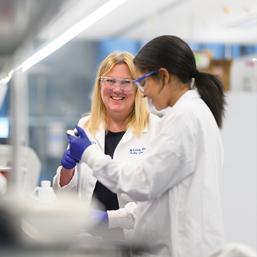 Dr Kolesar works with student in the lab