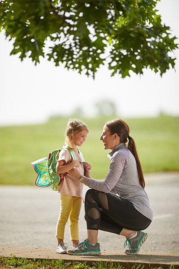 Mother embracing daughter before school