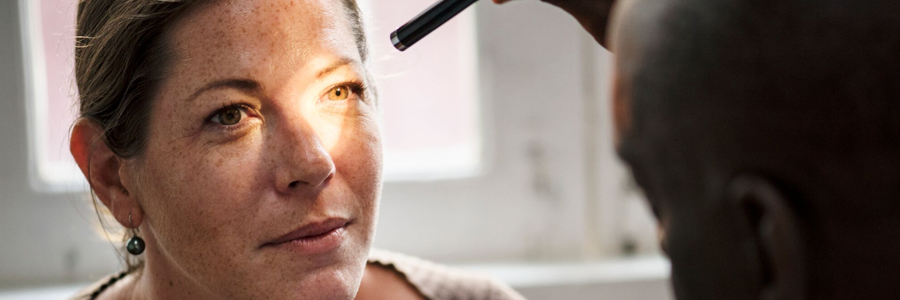 Doctor shining light in patient's eyes