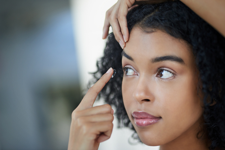 A woman inserts a contact lens.