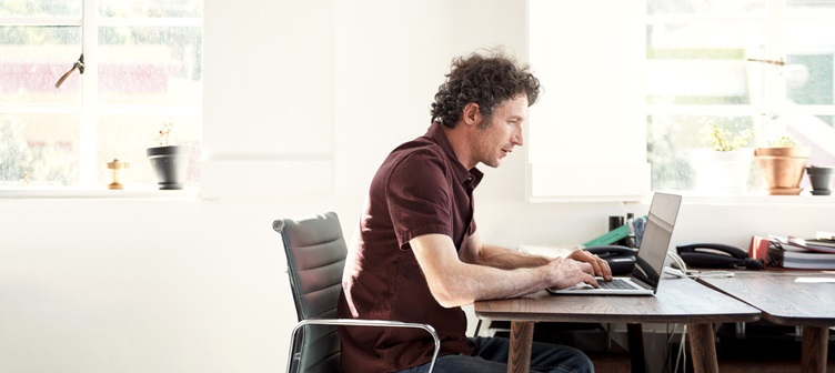 Man studies laptop.