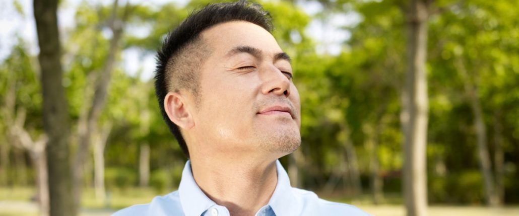 Man with closed eyes and uplifted face.