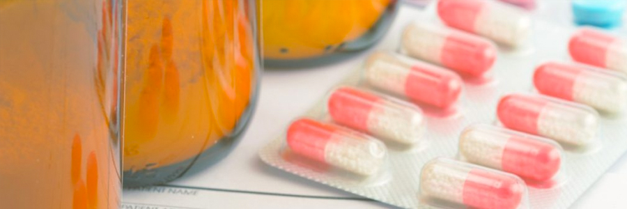 Medicine bottles and capsules in a blister pack on a shelf