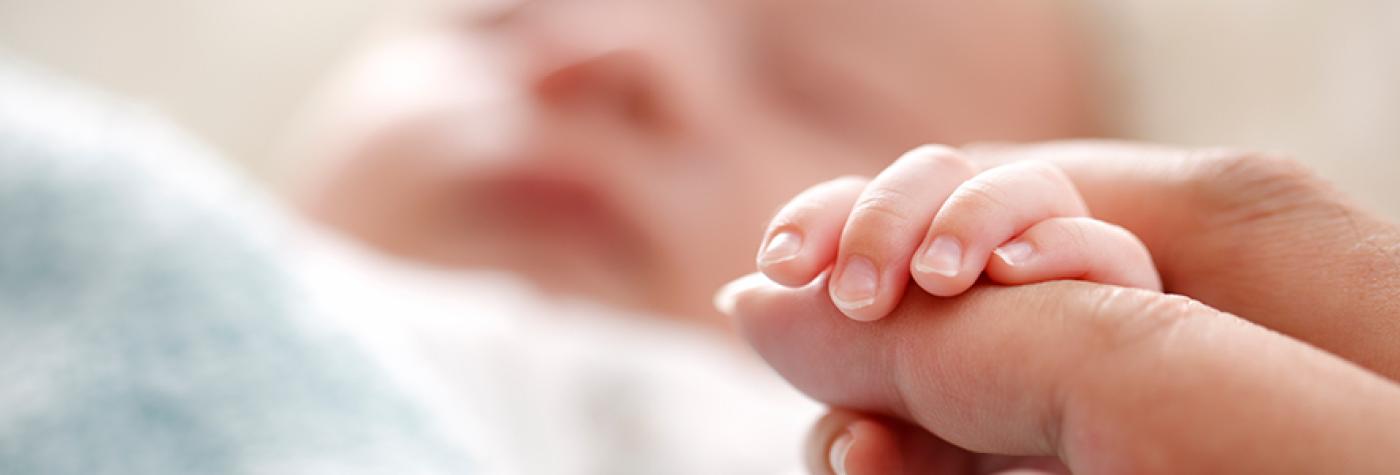 Baby holding their parent's finger