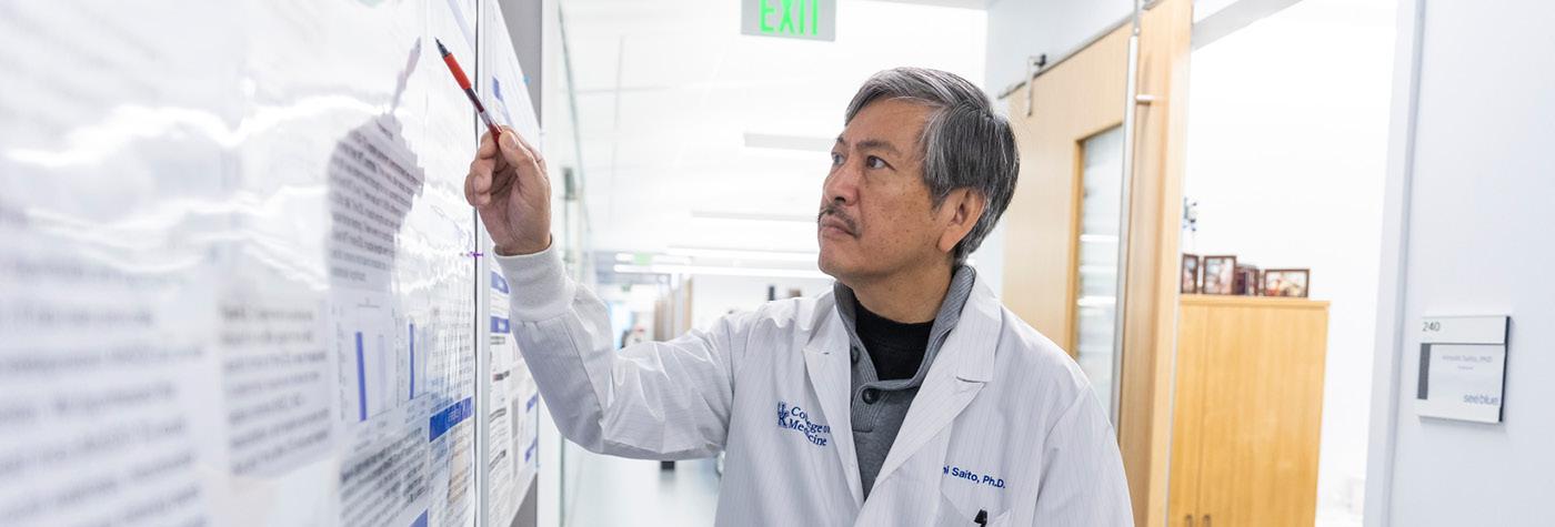 A researcher points to information on a whiteboard.