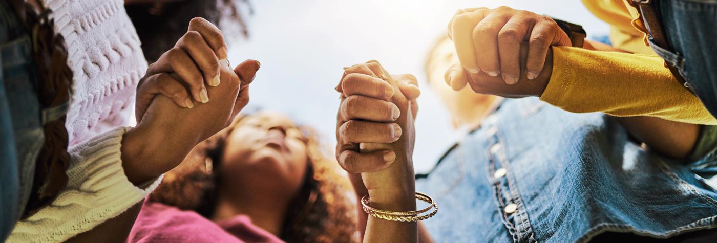 Cropped shot of a group of friends holding hands