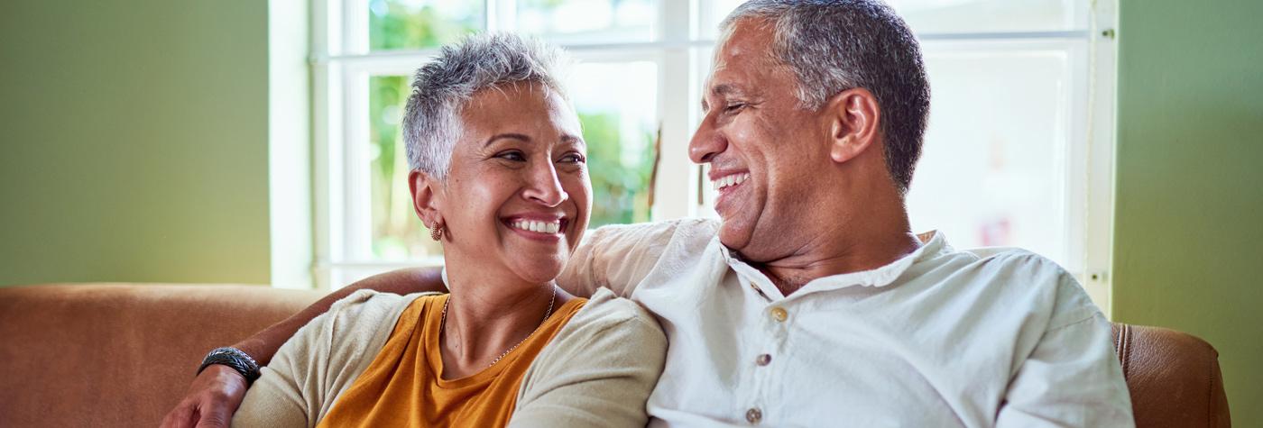 couple sitting on a couch looking at each other with hope