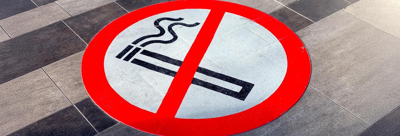 A no-smoking graphic painted on a floor