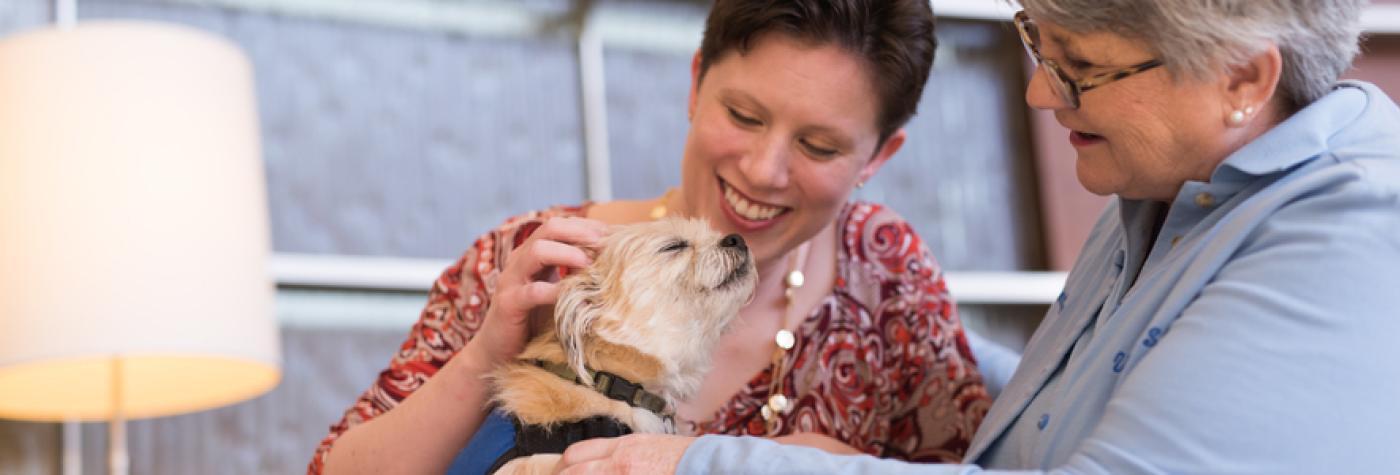 two women petting dog