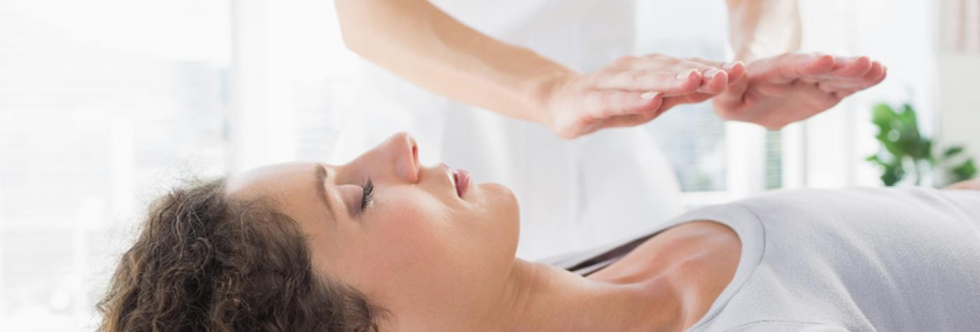 Woman receiving Reiki treatment.