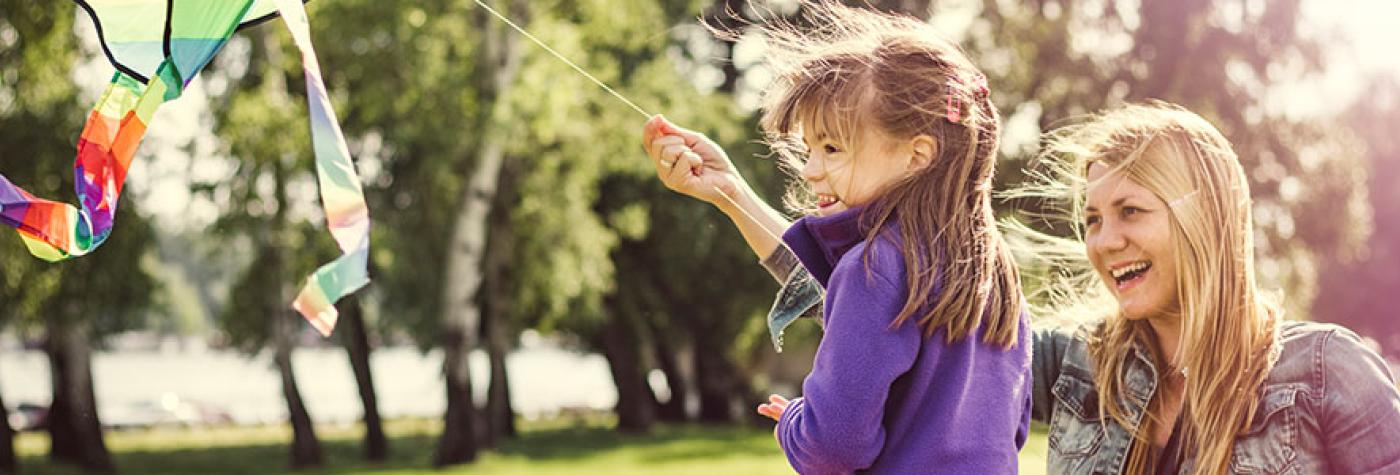 Mother and daughter flying kite in the park