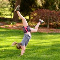 Sarah Beth does a handstand outside.