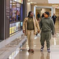 Tiona Stevenson, a UK HealthCare patient, walks down a hallway at UK Chander Hospital while holding the hand of her teenage son, Zaire.