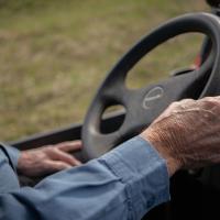 Close-up shot of Howard Galbreath's hand as it holds the wheel of a farm vehicle.