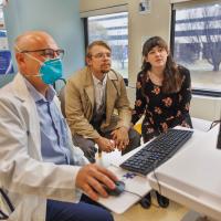 From left: Dr. Ralph Zinner, seated at a computer, shows Dave Custer and Sarah Custer images from her most recent screening.