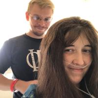 Dave Custer brushes his wife Sarah's hair while she's seated, wearing oxygen tubes.