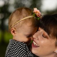 Sarah Custer, right, holds her daughter Isabel tightly, to her face. Close-up shot.