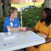 A UK HealthCare team member gives a hand massage to an event attendee.