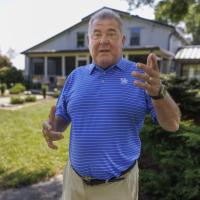 Bruce Drake speaking behind his house.