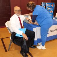 A nurse checks a man's blood pressure