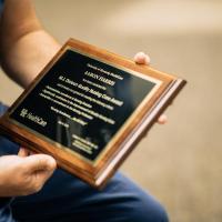 Aaron Harris holding a plaque for a nursing award