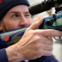 With his finger on the trigger, Addison looks through the rifle’s scope